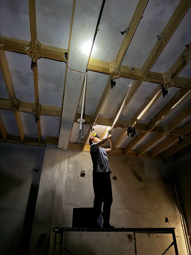Harvester reaching up to the nesting grid under a single lamp