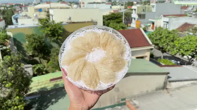 A finished tray of nests held up over the town